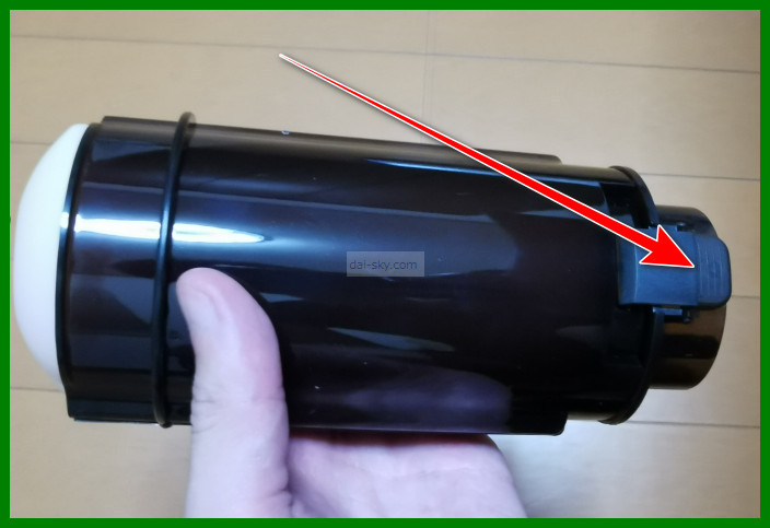 The black sleeve holder, with an arrow pointing to the tab that opens it