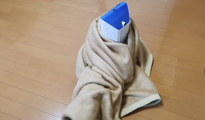 The A10 Piston SA wrapped in a beige blanket, standing upright on the floor