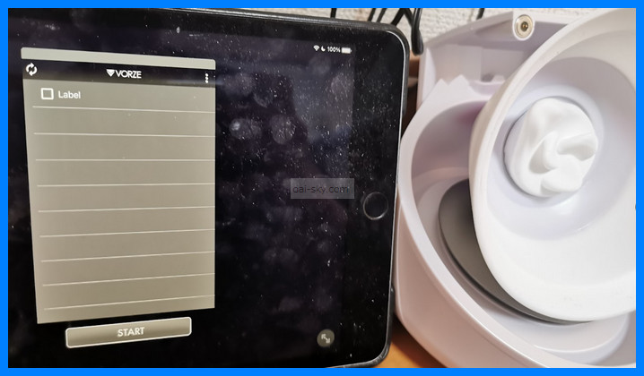 The iOS version of the VORZE app open on an iPad next to a U.F.O. TW cup
